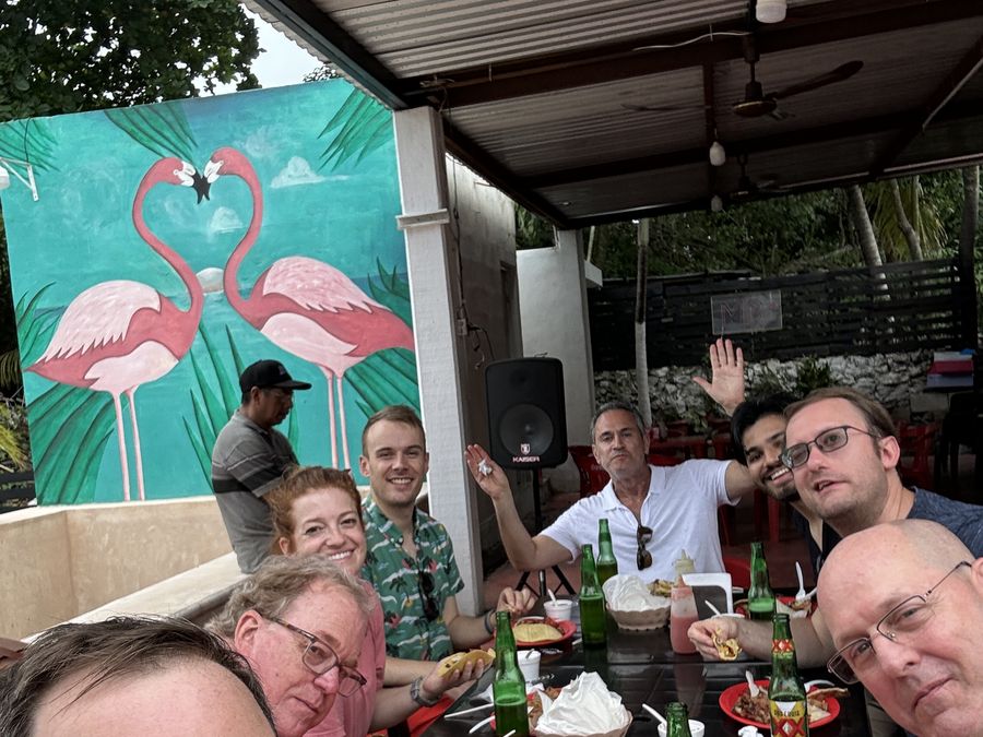 A group at lunch beneath an open-air palapa