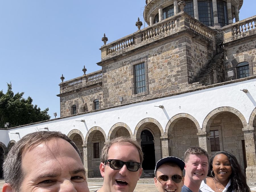 A group outside a historic stone building in the sunshine